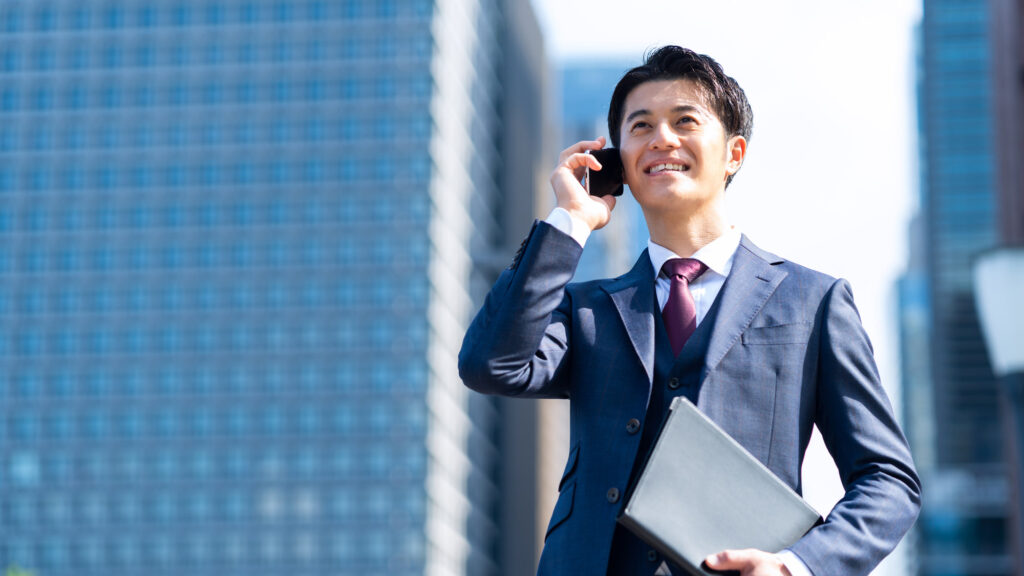 外で電話をする男性